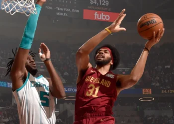 Jarrett Allen no ato de finalização da infiltração com a mão esquerda contra o defensor do Hornets.