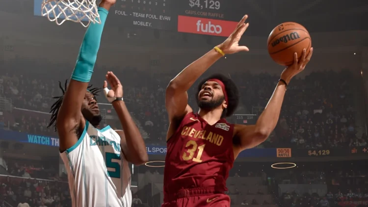 Jarrett Allen no ato de finalização da infiltração com a mão esquerda contra o defensor do Hornets.